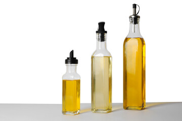 Bottles of different cooking oils on white background