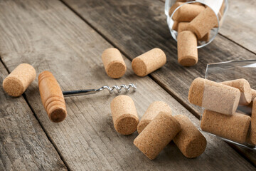 Fototapeta na wymiar Glasses with wine corks and corkscrew on wooden table