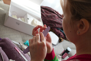 Young woman polish her fingernails at home