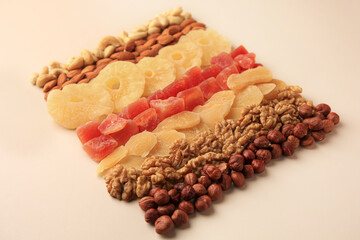 Different tasty nuts and dried fruits on beige background