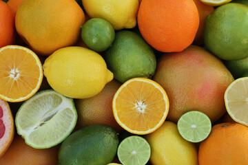 Different fresh citrus fruits as background, top view