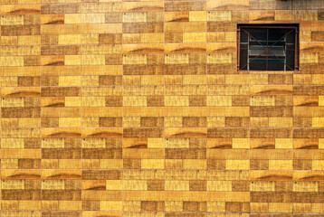 Fototapeta na wymiar Small barred window and a colored brick wall.