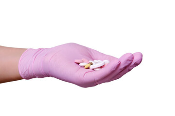 Hand in pink medical glove with a handful of pills, isolated on a white background