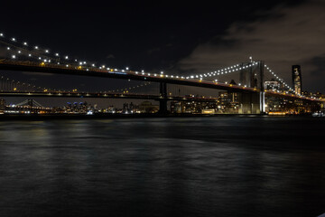 Fototapeta na wymiar Brooklyn bridge crossing into Brooklyn at night with epic lights