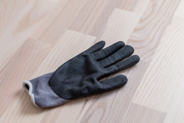 Fototapeta na wymiar Grey rubberized work gloves on wooden surface