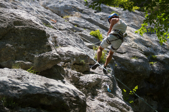 Chico joven haciendo escalada en la monta&ntilde;a