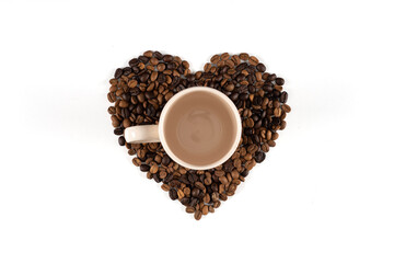Heart-shaped coffee beans on a white background, a coffee mug on coffee beans