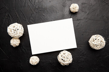 Obraz na płótnie Canvas Card mockup, blank wedding invitation with white white balls decor on black table
