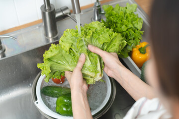 people washing raw vegetables at sink in the kitchen prepare ingredient for cooking