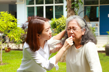 Family concept. daughter taking care of elderly mother Give inhalers to relieve fainting. Elderly health care. headache elderly