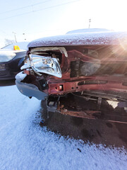 Front of an accident car in sunlight and with snow