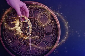 low key image of female hand holding beautiful queen or king crown. vintage filtered. fantasy medieval period