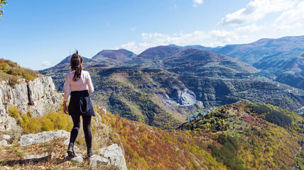 Naklejka na ściany i meble Traveler Woman standing on a rocks in the autumn mountain . Balkan mountains, ,Bulgaria