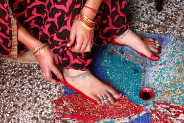 Naklejka premium Woman applying red dye on her soles