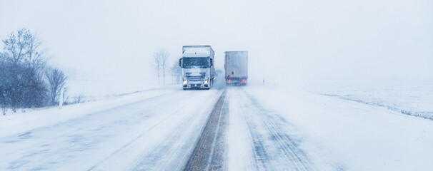 Freight transportation truck on the road in snow storm blizzard
