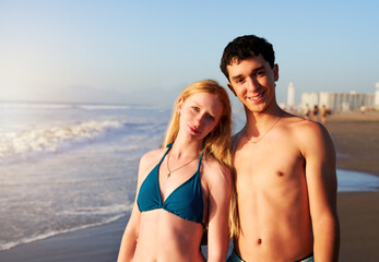 portrait two young Argentinians standing on the shore of the beach looking at camera and smiling 
