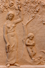 Sculpture depicting a mother picking an orange