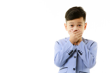 A 10-year-old Asian boy covers his mouth with his hand with an excited expression on his face. A concept for silence, shock and excitement. On a white isolate background - 557931135