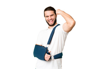 Young handsome man with broken arm and wearing a sling over isolated chroma key background...