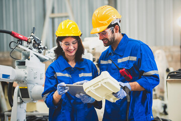 Engineers team mechanic using computer controller Robotic arm for welding steel in steel factory...