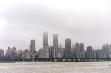 Fototapeta na wymiar Hudson river in Winter with Misty New Your Cityscape in Background.