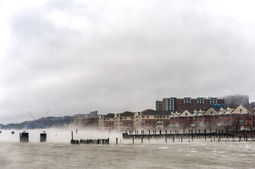 Hudson river in Winter with Misty Edgewater Cityscape in Background. New Jersey, USA