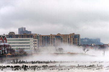 Hudson river in Winter with Misty Edgewater Cityscape in Background. New Jersey, USA