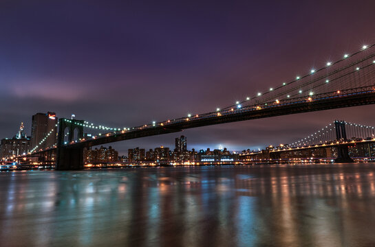 Brooklyn Bridge and Manhattan Bridge at Night. Long Exposure. New York. NYC, USA. Lights Reflection on Water.at Night.