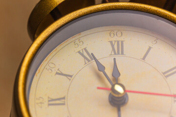 Fototapeta na wymiar Retro alarm clock with five minutes to twelve o'clock. Old style filtered photo