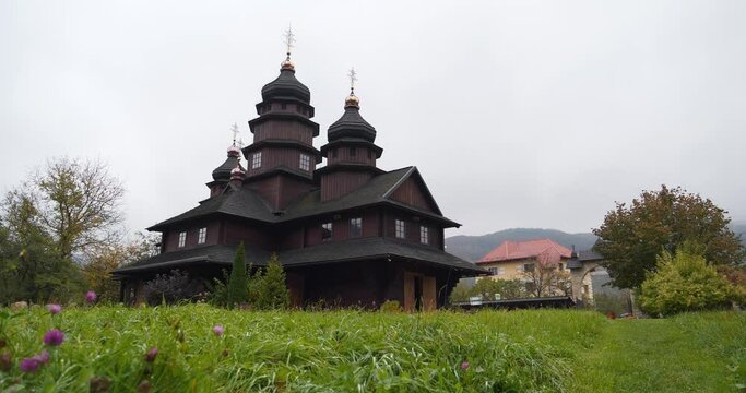 Church of Holy Prophet Ilya - unique architectural monument built in Hutsul style in shape of cross in Yaremche city, Carpathian Mountains in western Ukraine. Cinema 4K 60fps zoom-out video