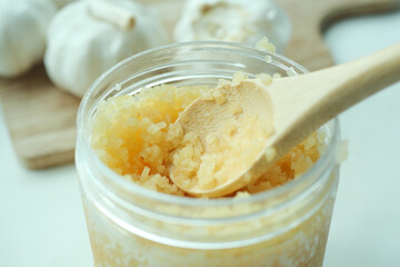 close up of minced garlic on a wooden spoon 