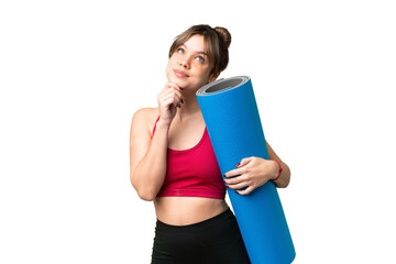 Young sport girl going to yoga classes while holding a mat over isolated chroma key background and...