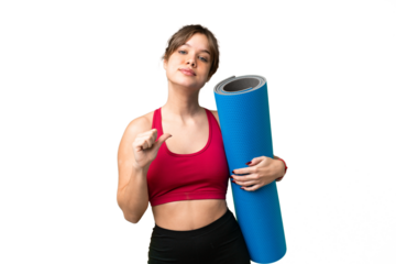 Young sport girl going to yoga classes while holding a mat over isolated chroma key background proud and self-satisfied