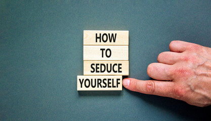 How to seduce yourself symbol. Concept word How to seduce yourself on wooden blocks. Businessman hand. Beautiful grey table grey background. Business and how to seduce yourself concept. Copy space.