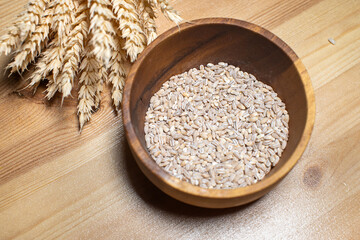 Cereal crops lie in a wooden plate on the table