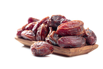 Dates in a wooden dish isolated on a white background.