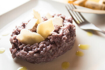 Risotto with red cabbage and parmesan. Risotto is a northern Italian rice dish cooked with broth until it reaches a creamy consist.