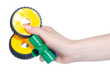 Children's plastic constructor with wheels in hand on white background isolation