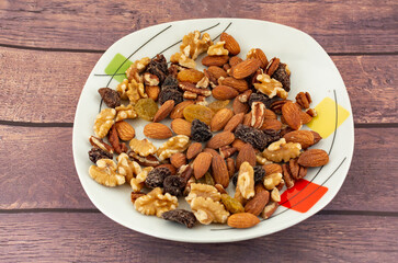 Nuts on a plate with almonds, walnut, brown raisin and blonde raisin
