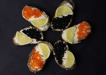 delicious fragrant sandwiches or bruschetta with melted cheese and black caviar and red caviar and lemon on a dark background. for splash screens labels flyers menu banners