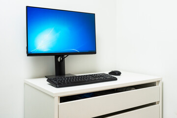 Fototapeta premium Desktop computer on white table in white walled room