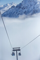 ski lift in the mountains above the clouds
