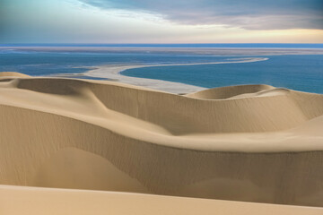 Namibia, the Namib desert, landscape of yellow dunes falling into the sea
