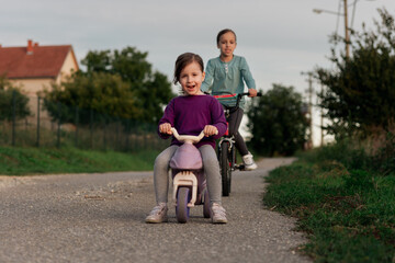 Naklejka na ściany i meble Children riding bike on the street