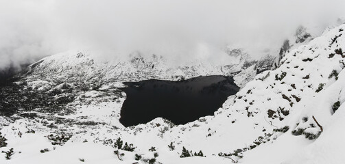 Panorama w chmurach na Czarny Staw Gąsiennicowy . Tatry Polskie w zimowej aurze z dużą ilością...