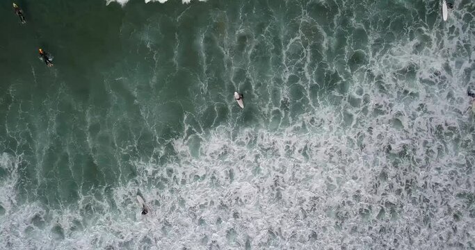 Top down aerial over surfers in abstract wave sets blending and swirling