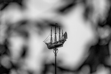 Fototapeta na wymiar Ornate naval weather vane through the trees, London, UK 