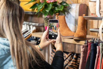 Woman taking a photo of some shoes in a clothing store