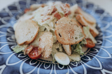 Healthy salad plate with different lettuce, chicken, cheese and tomatoes cherry on the table in restaurant. Grilled chicken breasts and fresh vegetables top view, flat lay