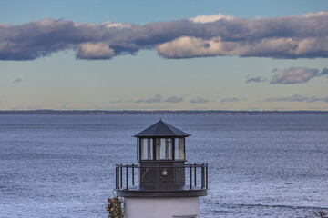 Fototapeta na wymiar Lighthouse Under Clouds Landscape, At The Ocean Shore, Maine, US